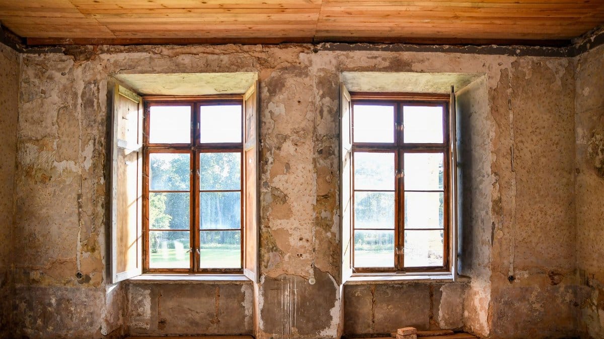 Abandoned room in Kolga manor with rustic windows, natural light highlighting the weathered walls.