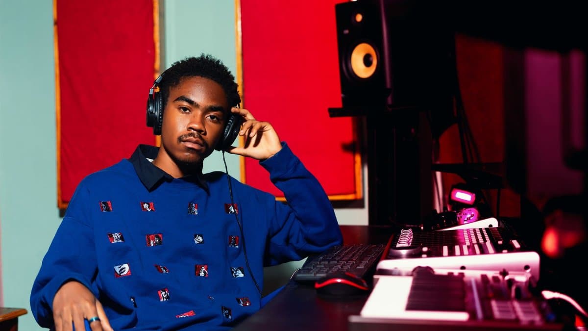 Young music producer in a vibrant studio setting working on new electronic tracks.