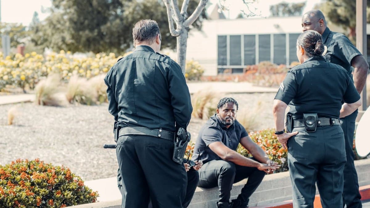 Law enforcement officers interacting with a person outdoors, displaying cooperation and safety enforcement.