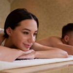 Couple receives relaxing massage treatment in serene spa setting.