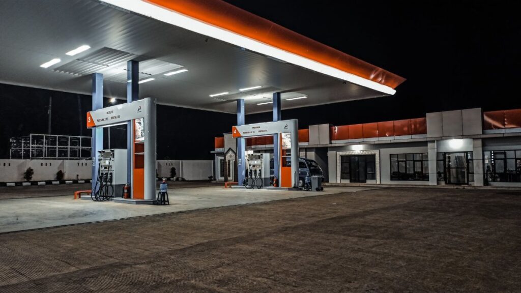 A contemporary gas station illuminated at night, highlighting pump stations and canopy.