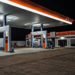 A contemporary gas station illuminated at night, highlighting pump stations and canopy.