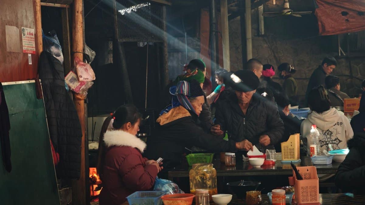 Indoor scene capturing people dining at a rustic market with warm lighting.