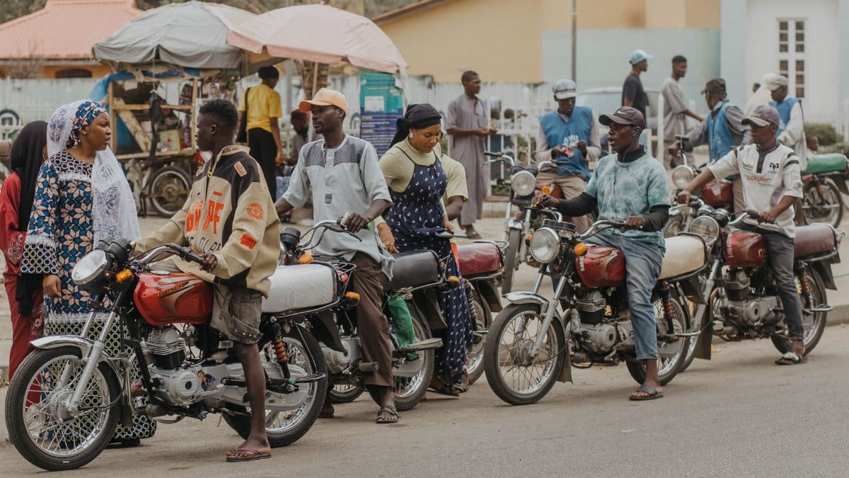 A vibrant street scene featuring people interacting with motorcycles.