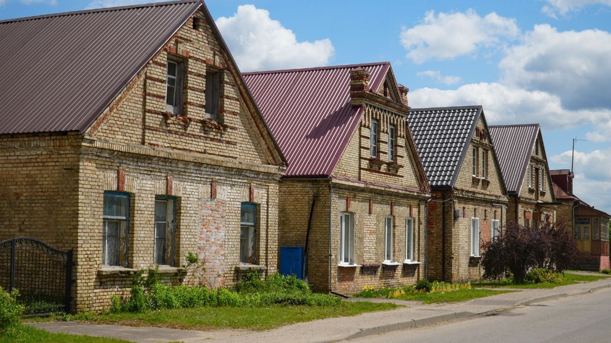 Charming brick houses with gable roofs on a sunny day in Grodno Region, Belarus.
