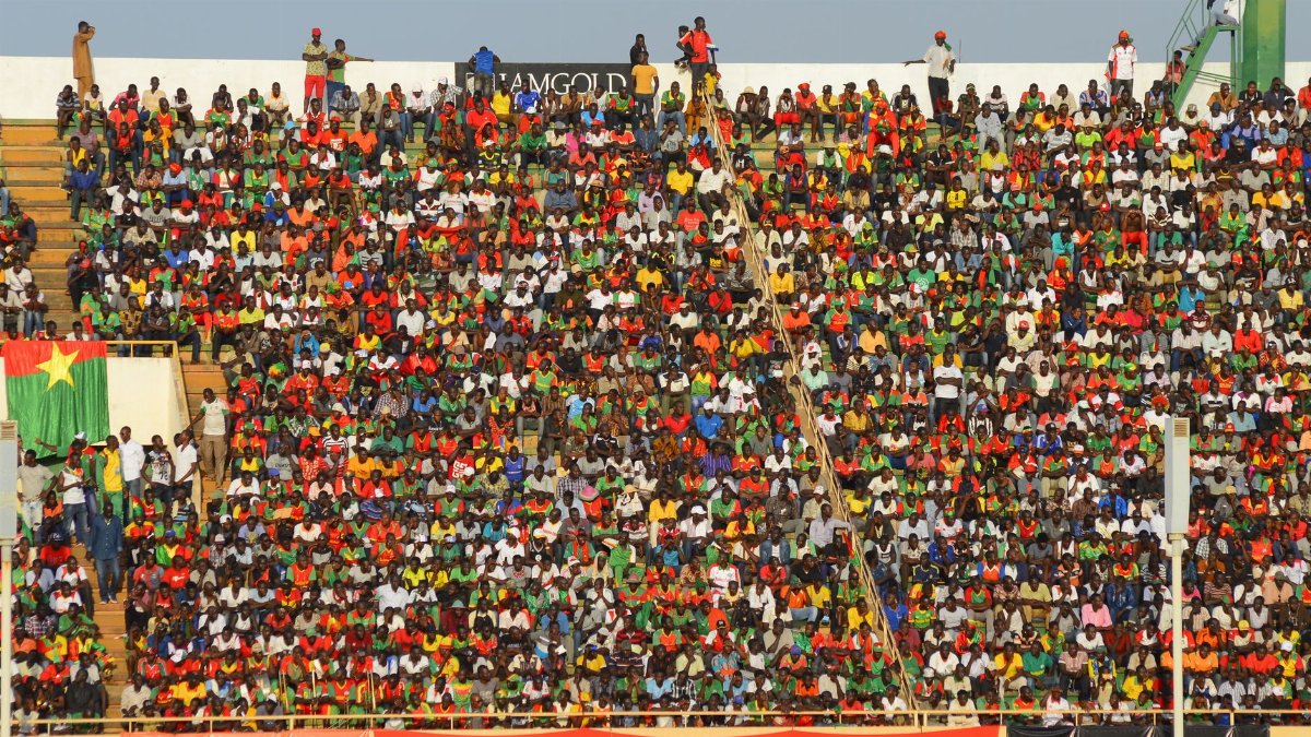 Vibrant crowd of soccer fans fills stadium seats during an exciting football match.
