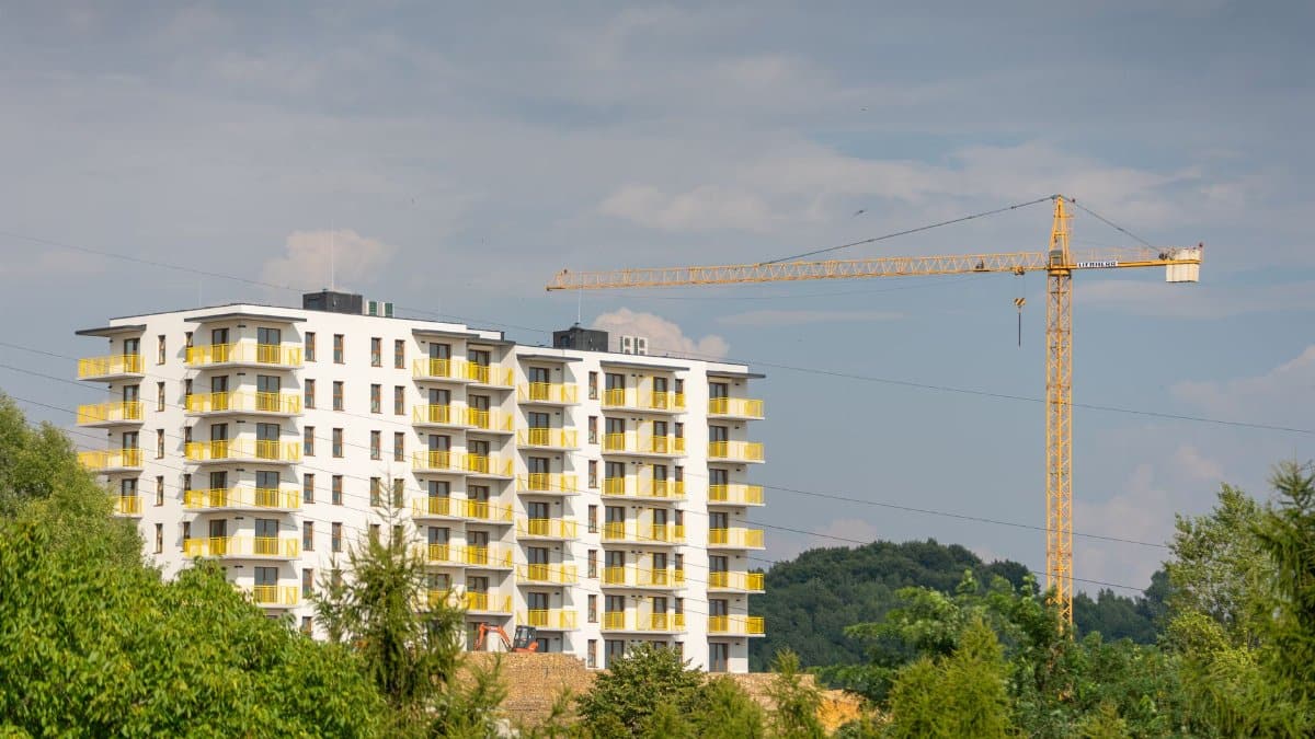 View of an apartment building under construction with a crane in Trzebinia, Poland.