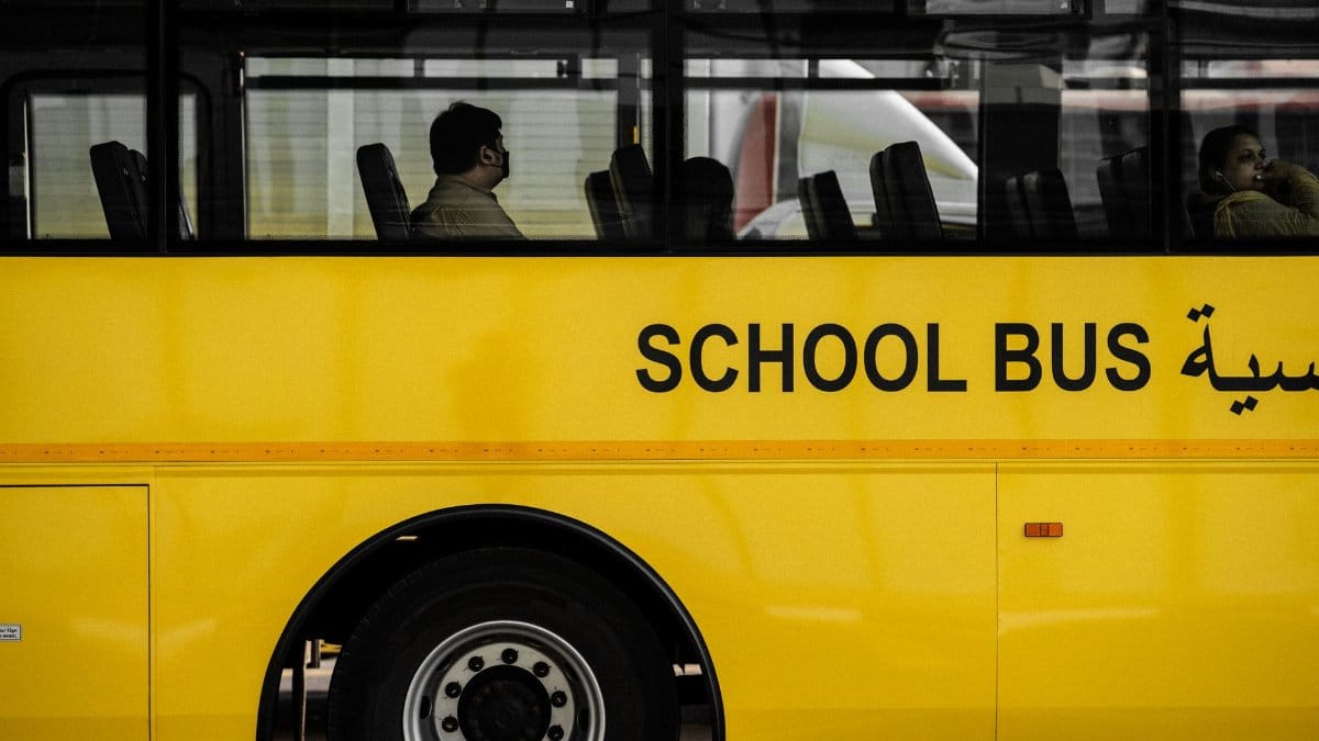 A modern yellow school bus with passengers seen through the windows. Ideal for urban transportation themes.