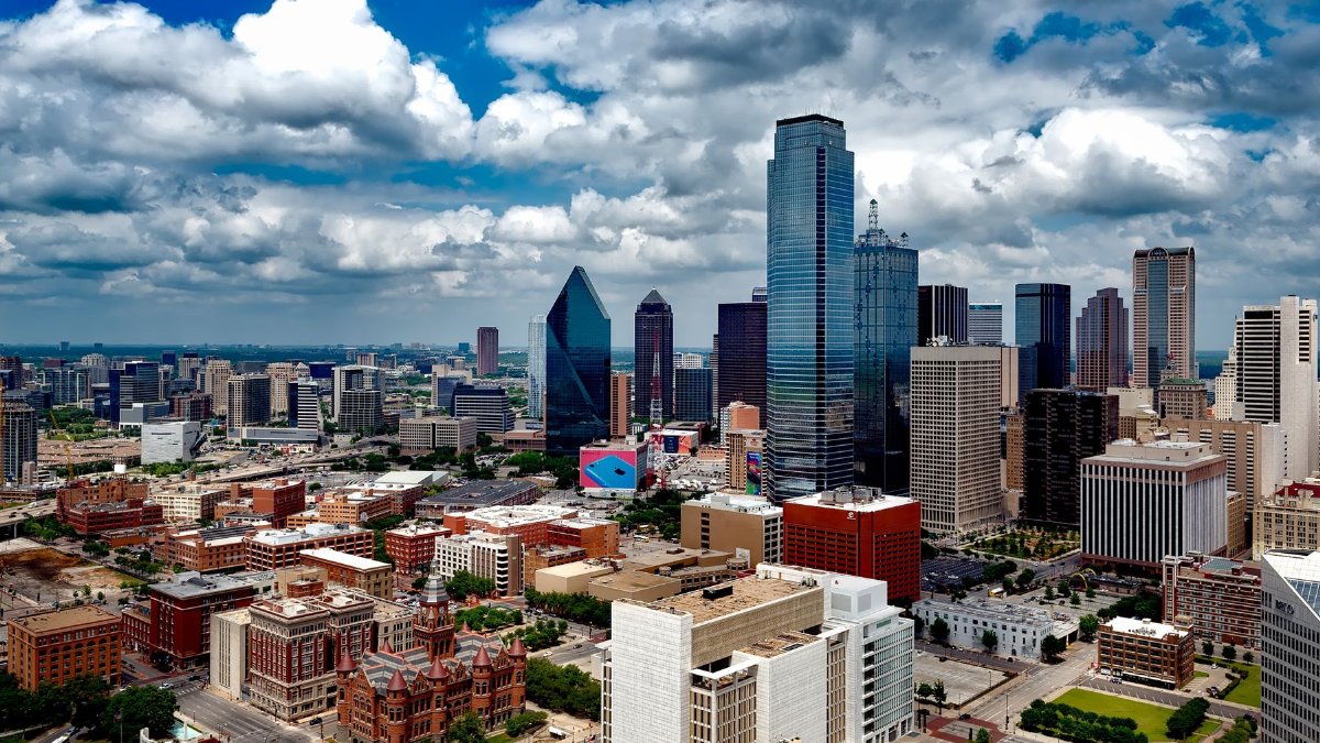 A stunning panoramic view of the Dallas skyline under dramatic clouds, capturing the city's iconic skyscrapers.