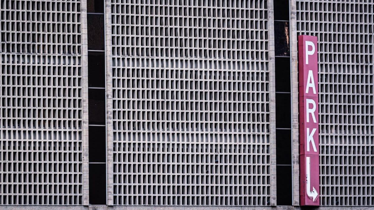Close-up of urban parking garage facade with red sign in Dallas, Texas.