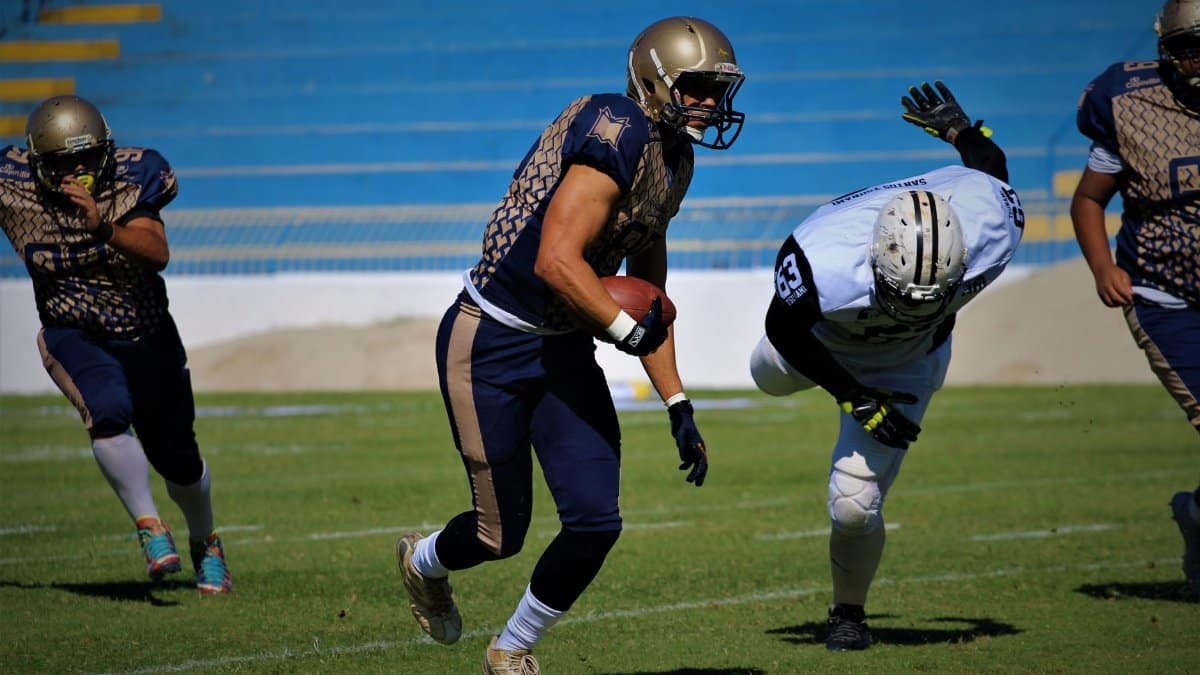 Players in action during a competitive football game on the field, showcasing teamwork and athleticism.