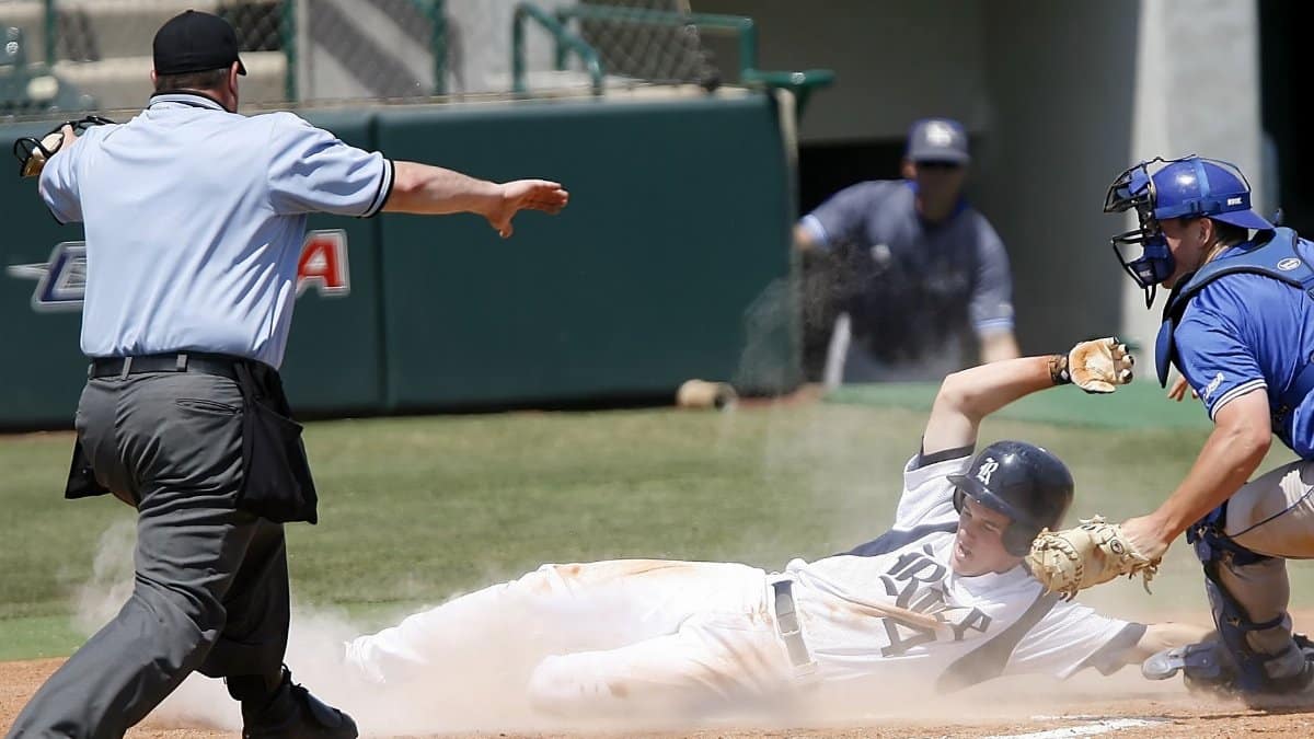A thrilling baseball game moment as a player slides to home plate under pressure from the catcher.
