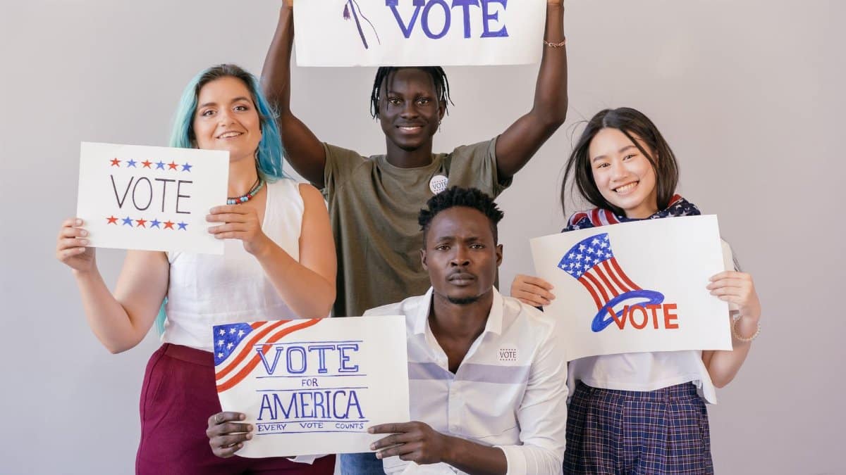 Diverse group of young adults proudly holding signs to encourage voting in America.