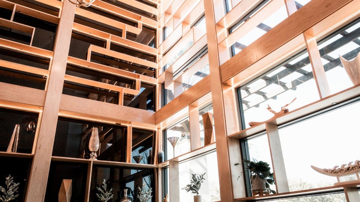 Stylish interior featuring wooden decor, glass panels, and elegant decor elements in natural light.