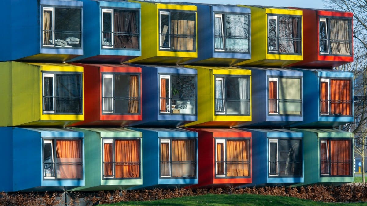 Vibrant exterior of colorful modular housing units with varied window designs.