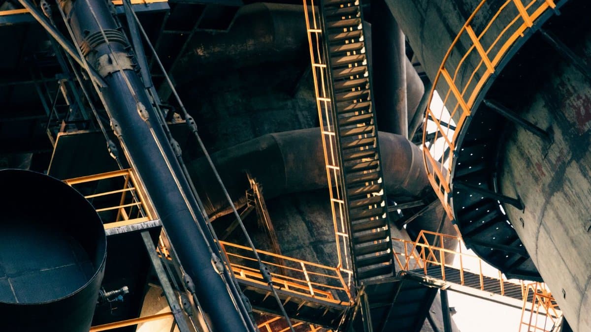 Intricate view of metal stairs and structures in a large industrial facility.
