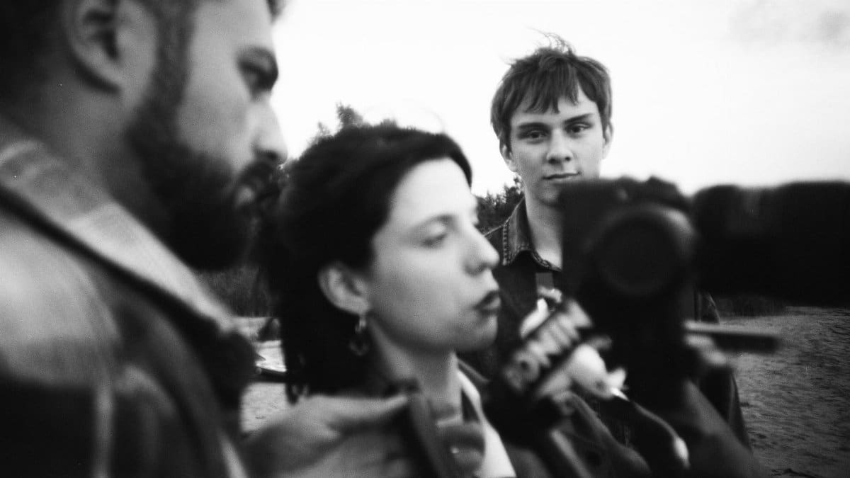 Black and white outdoor media interview with people and camera focus.