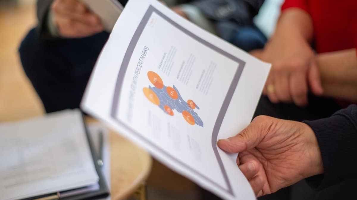 Close-up of professionals reviewing business documents in a meeting setting.