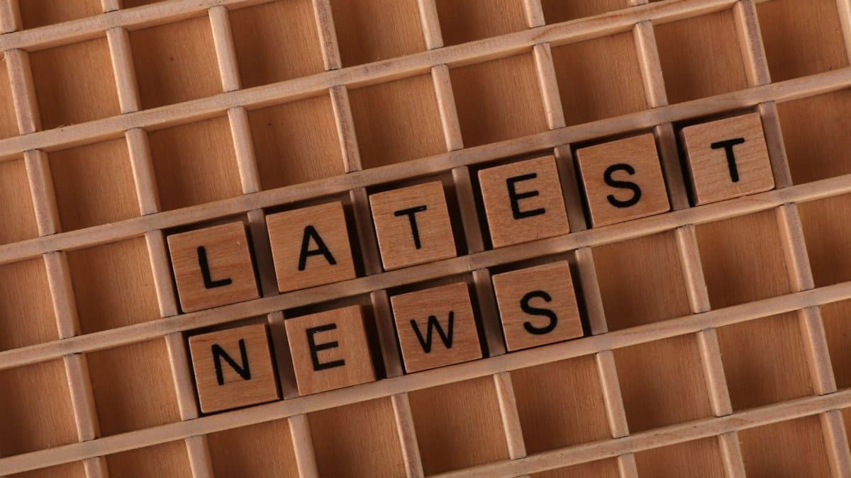 Wooden letter blocks spelling 'Latest News' on a grid surface. Ideal for media concepts.
