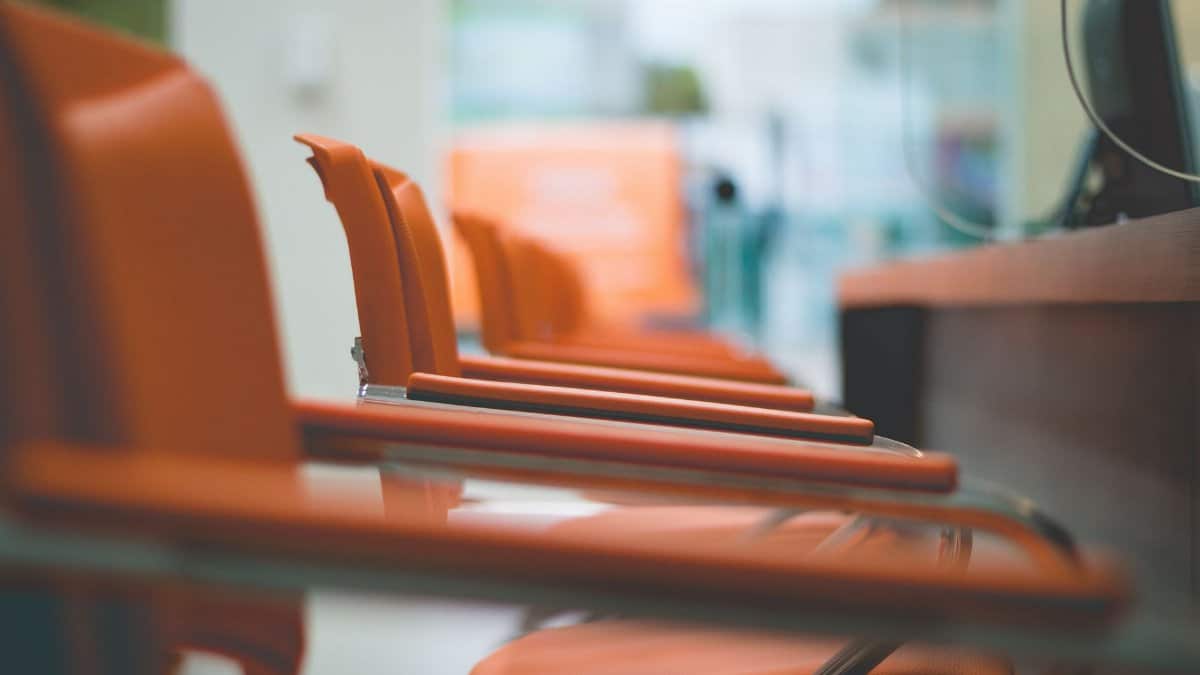 Close-up of sleek orange office chairs in a waiting area with focus on design.