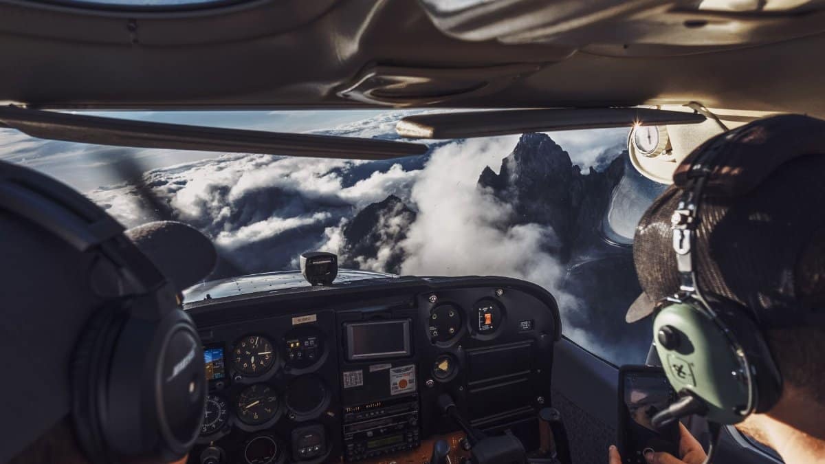 Pilot's perspective of flying over clouds and mountains, capturing the breathtaking view.