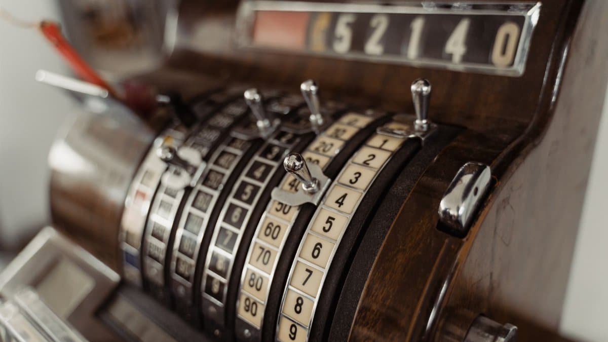 Close-up of a vintage cash register showing mechanical dials and levers.