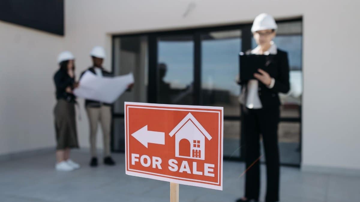 Three real estate professionals inspecting a property for sale with a focus on the business aspect.