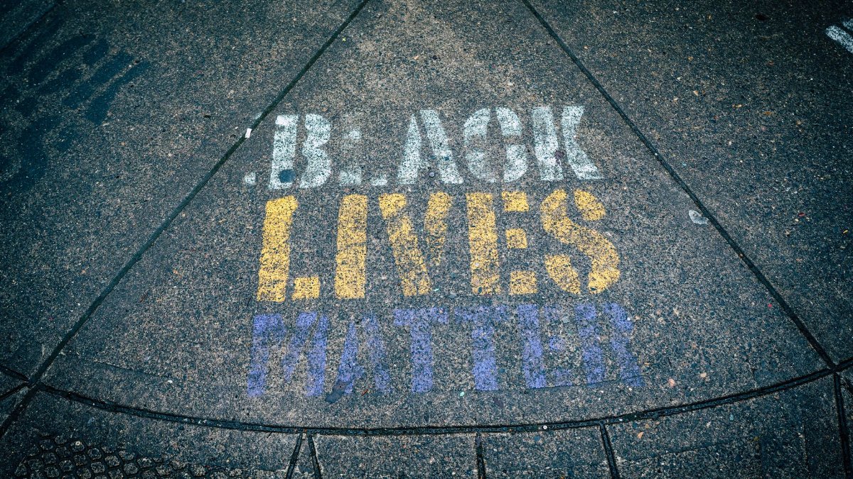 Bold Black Lives Matter message on sidewalk in vibrant colors, promoting equality and activism.