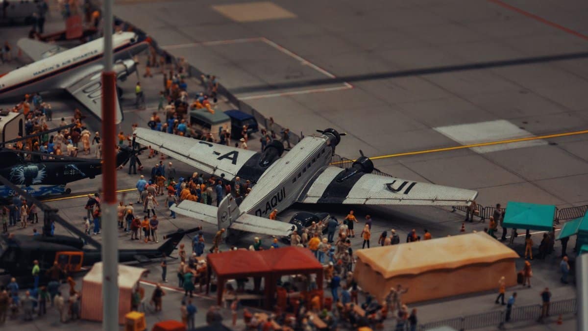 A detailed miniature scene of airplanes and people at a crowded airport display.