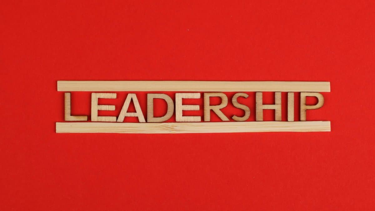 Wooden letters spelling leadership on a vibrant red background, conveying bold concepts.
