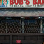 Rustic exterior of Bob's Bar with vintage sign, showcasing outdoor seating area.