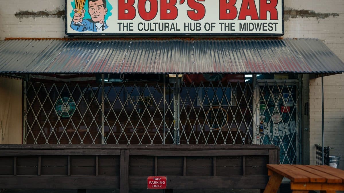 Rustic exterior of Bob's Bar with vintage sign, showcasing outdoor seating area.