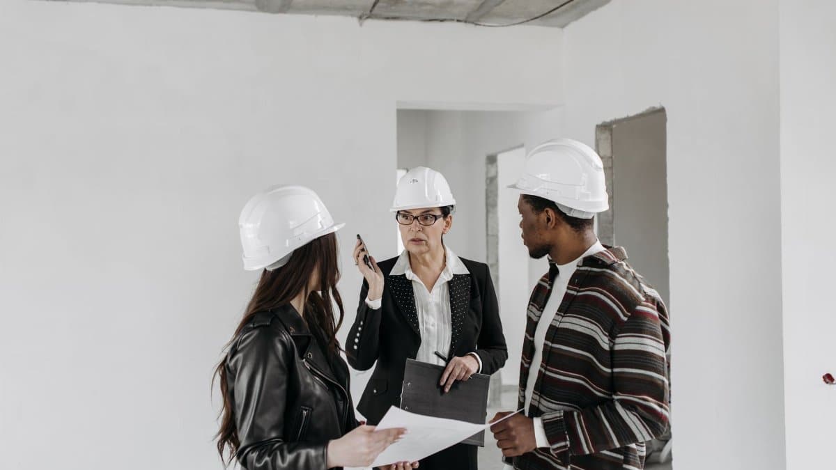 Construction professionals reviewing project plans inside a building site.