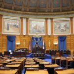 A beautiful view of the Massachusetts State House chamber with elegant decor and empty seating.