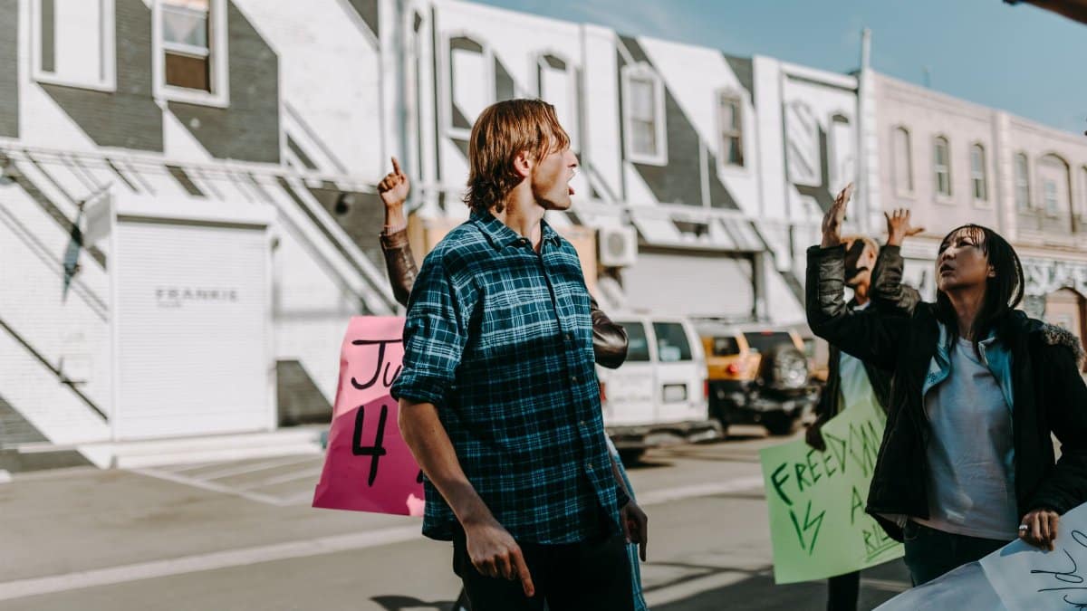 A group of protesters holding vibrant signs during a peaceful street rally.