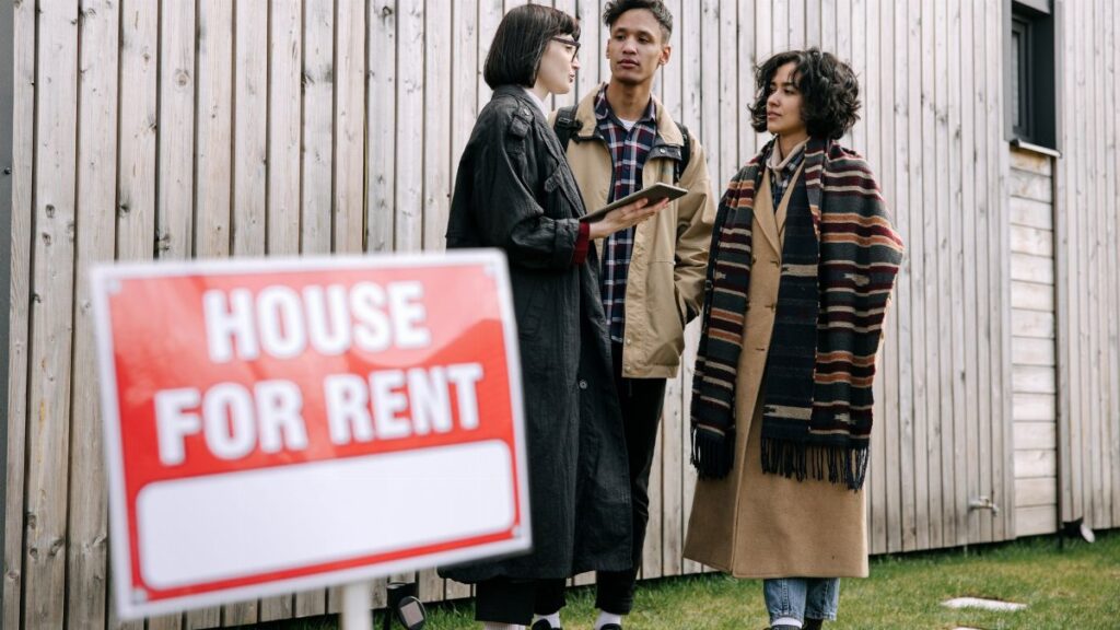 An interracial couple meets with a real estate agent to inquire about a house for rent.