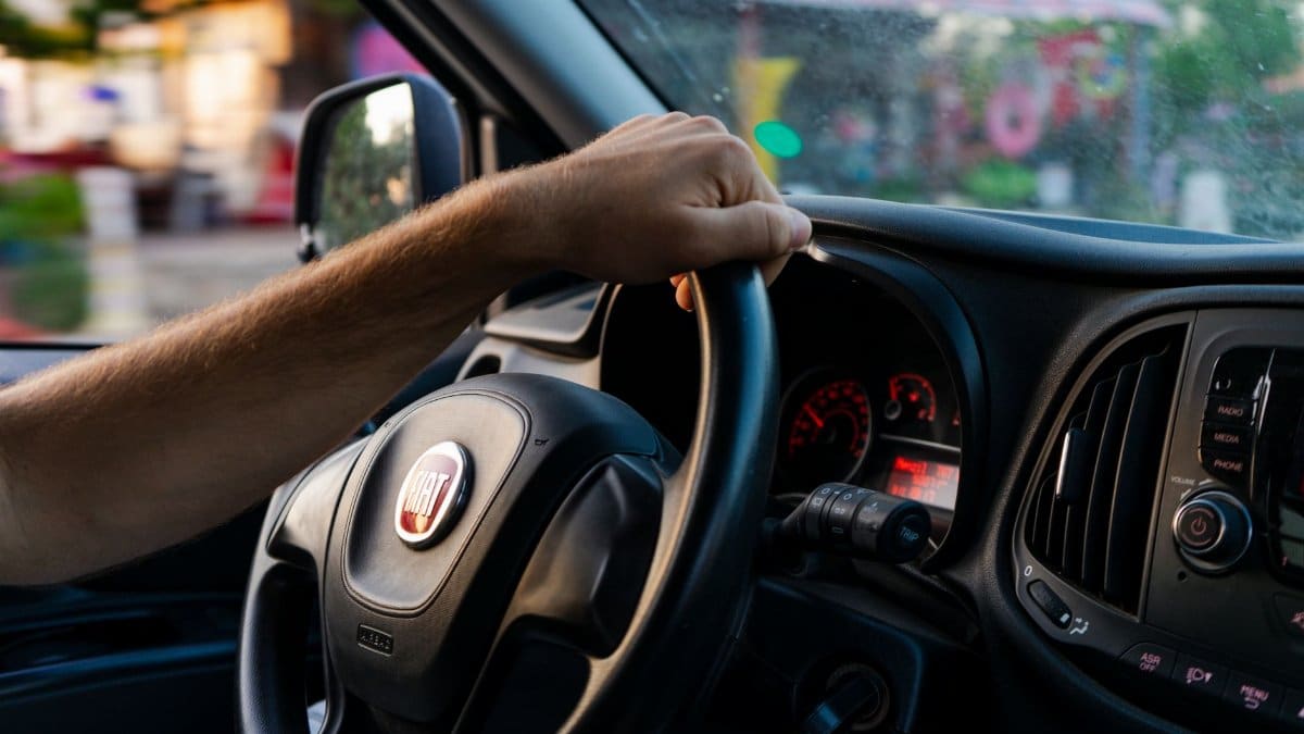 Close-up of a hand on a Fiat steering wheel while driving in Fethiye, Türkiye.