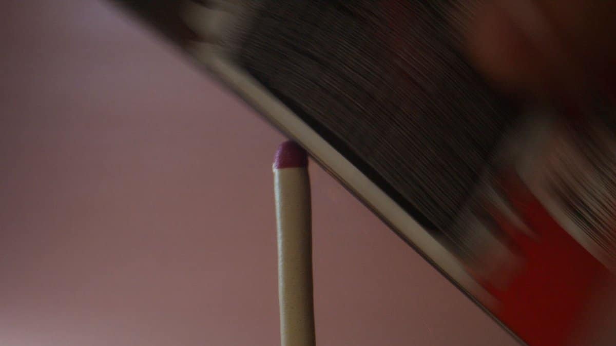 Close-up of a matchstick being struck, showcasing friction in action.
