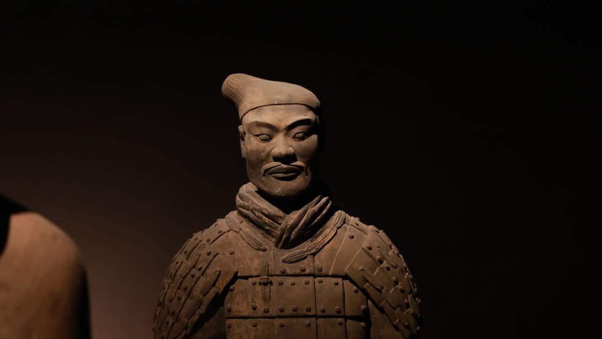 Close-up of a Terracotta Warrior statue with artistic lighting, capturing its detailed, historic features.