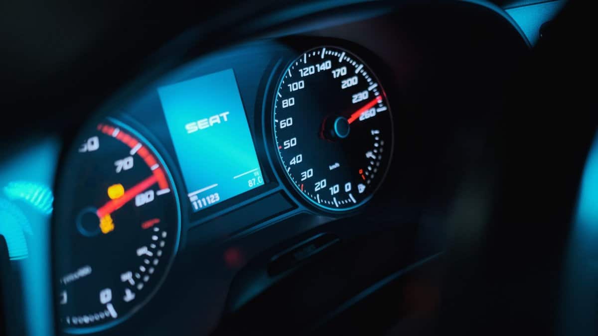 Vibrant close-up of a car speedometer displaying high speed and digital screen in a modern vehicle.