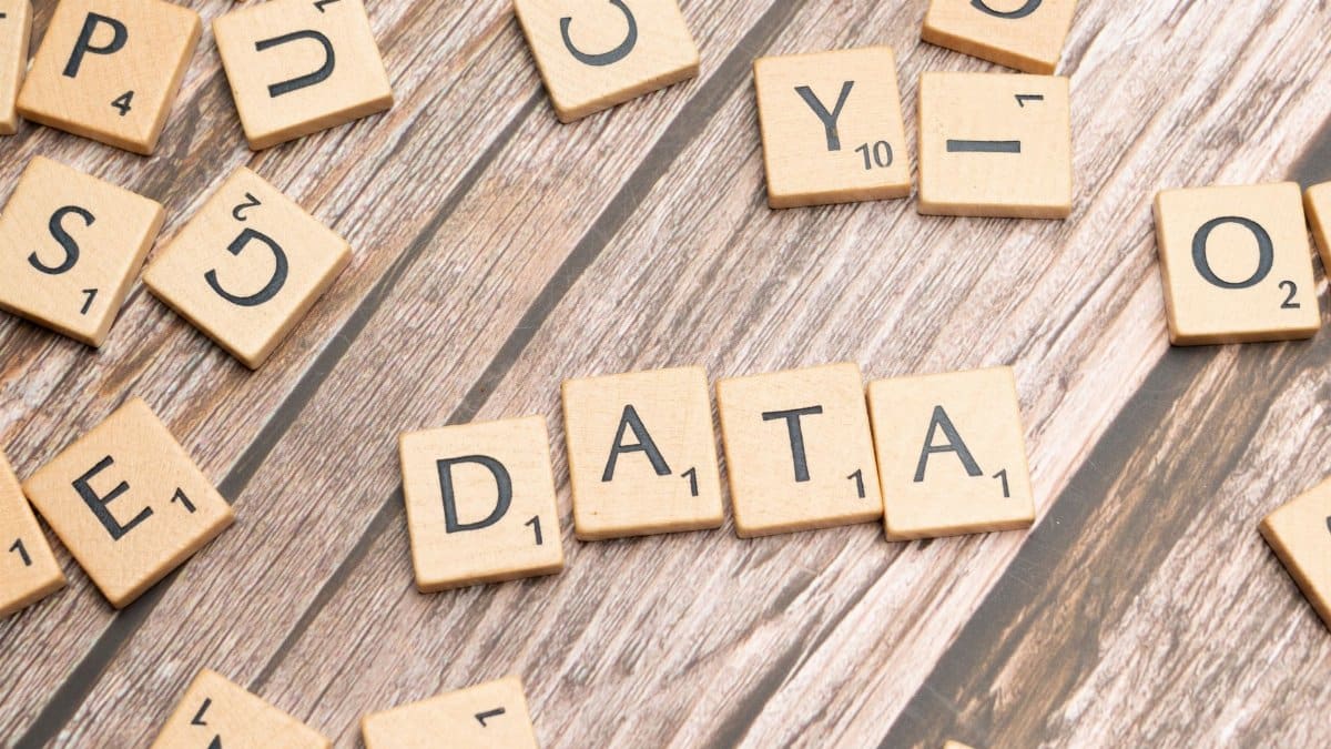 Wooden letter tiles spelling 'DATA' on a wood textured surface, symbolizing data concepts.
