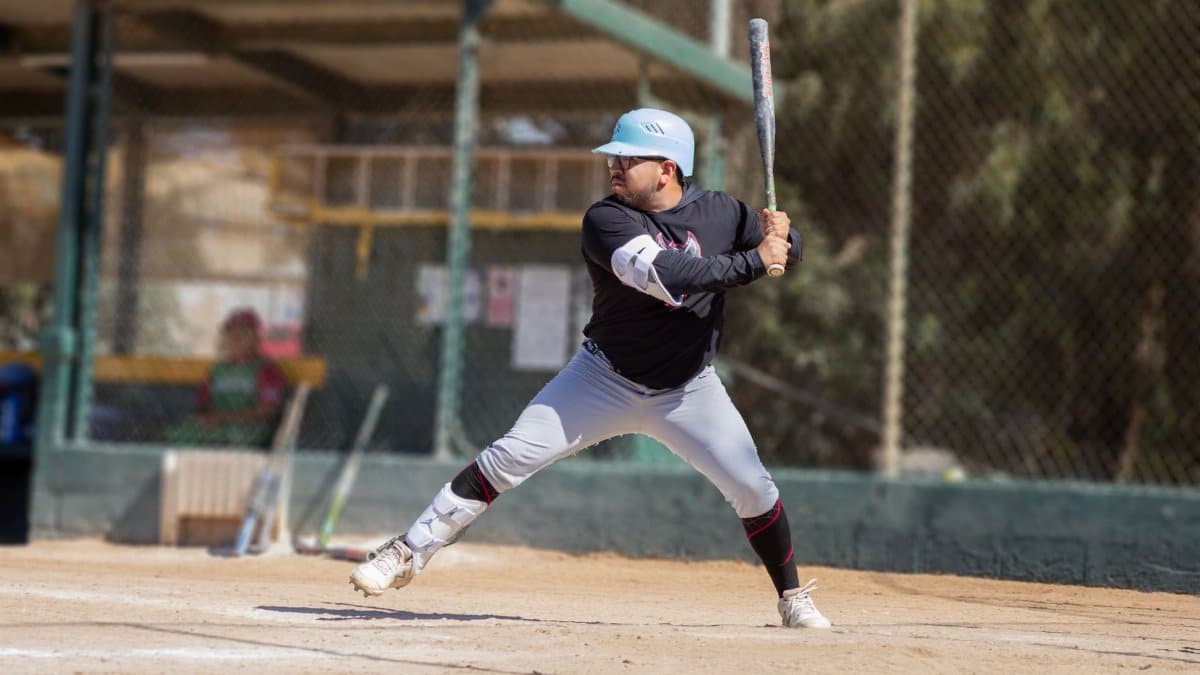 A baseball player poised to swing during a game on an outdoor field.