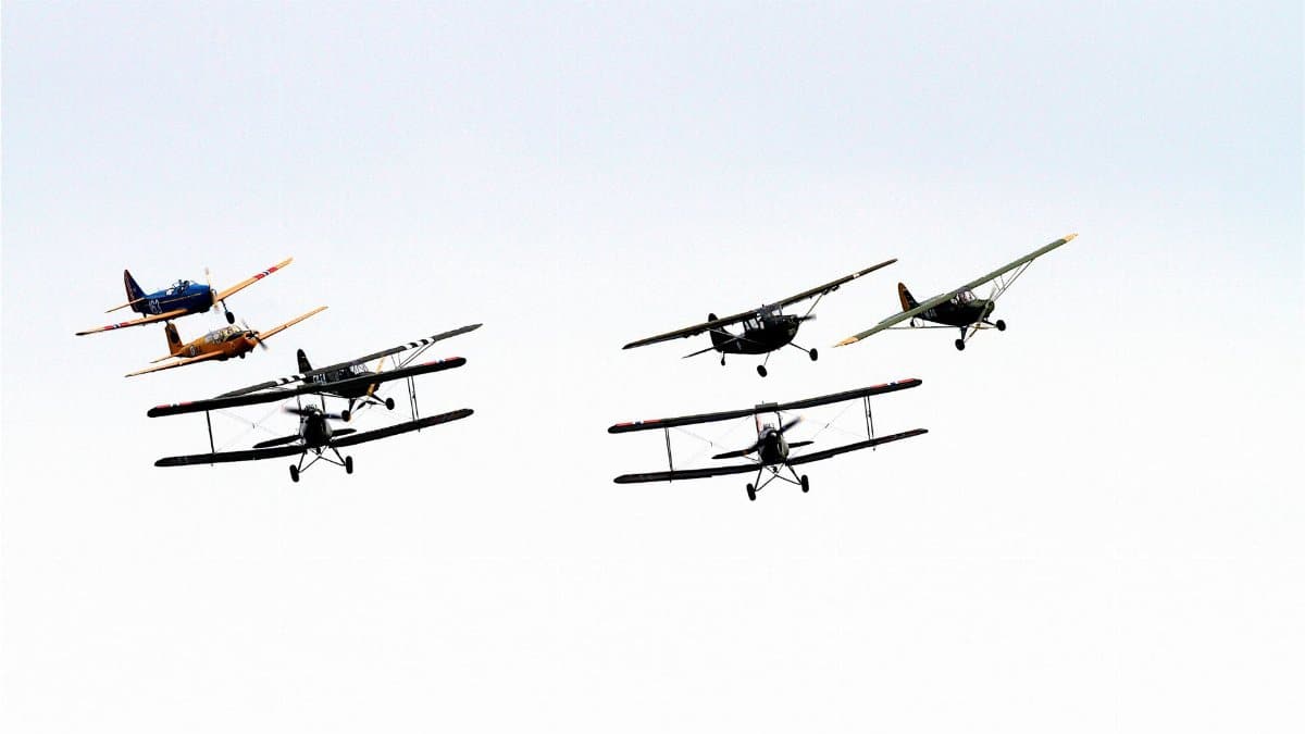 A group of vintage airplanes in flight, displaying a captivating aerial formation.