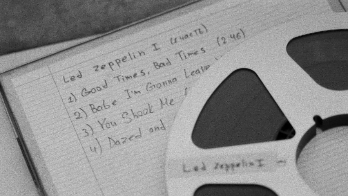 Close-up of a retro reel and handwritten music notes, evoking nostalgia.