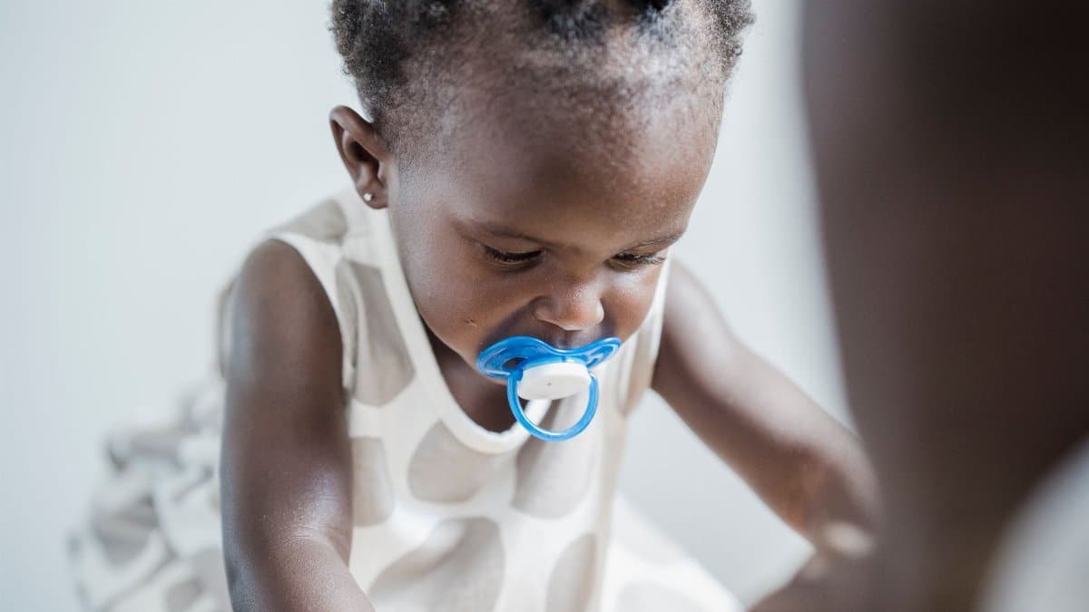 Close-up portrait of an adorable child with a pacifier, showcasing innocence and warmth.