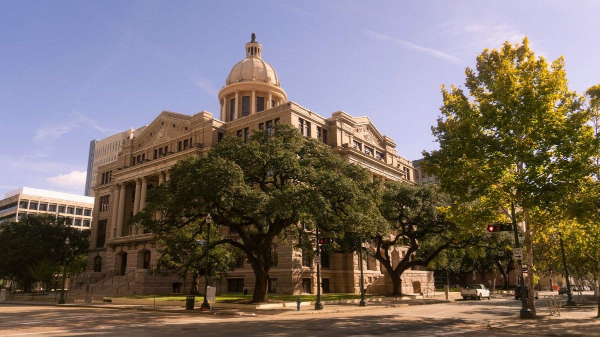 Stunning view of a historic courthouse building with trees, in downtown Houston, Texas.