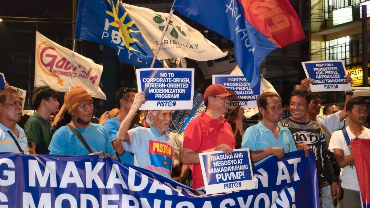 Group of people rally against corporate-driven modernization in a city street.