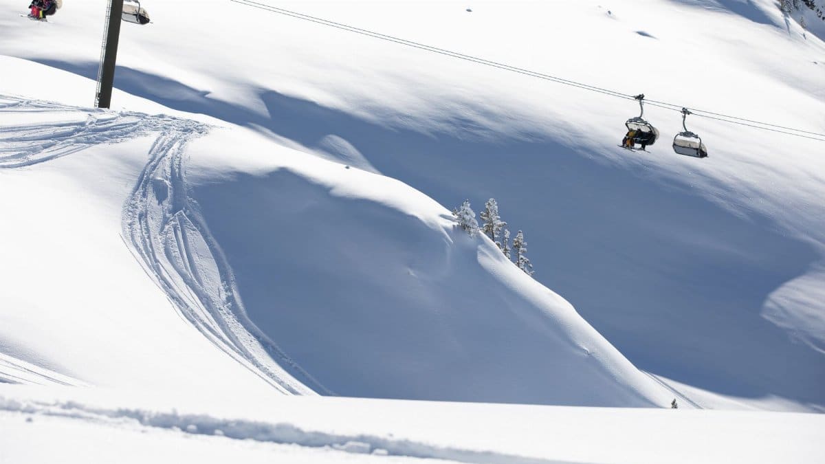 Ski lift transporting people over snowy slopes in a winter wonderland setting.