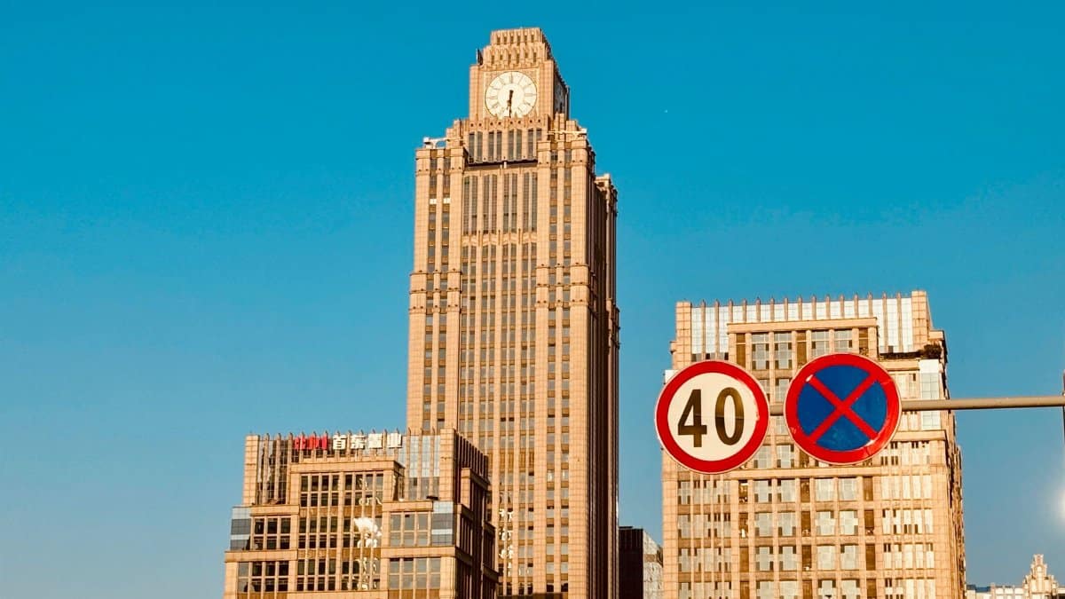 City skyline featuring modern skyscrapers and street signs under a clear blue sky.