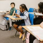 A diverse group of children in a classroom, focusing on social interactions and technology use.